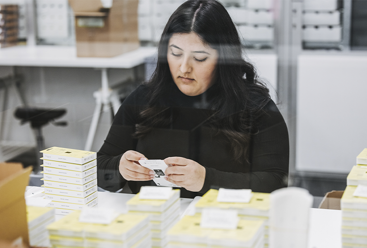 Angelbird collaborator packing products at a workstation, preparing items for shipment or storage.